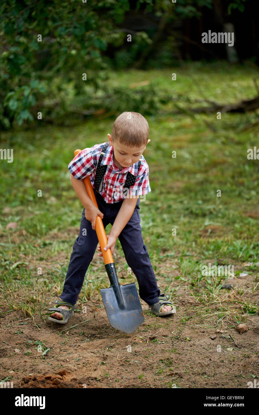 funny boy with shovel in garden Stock Photo Alamy