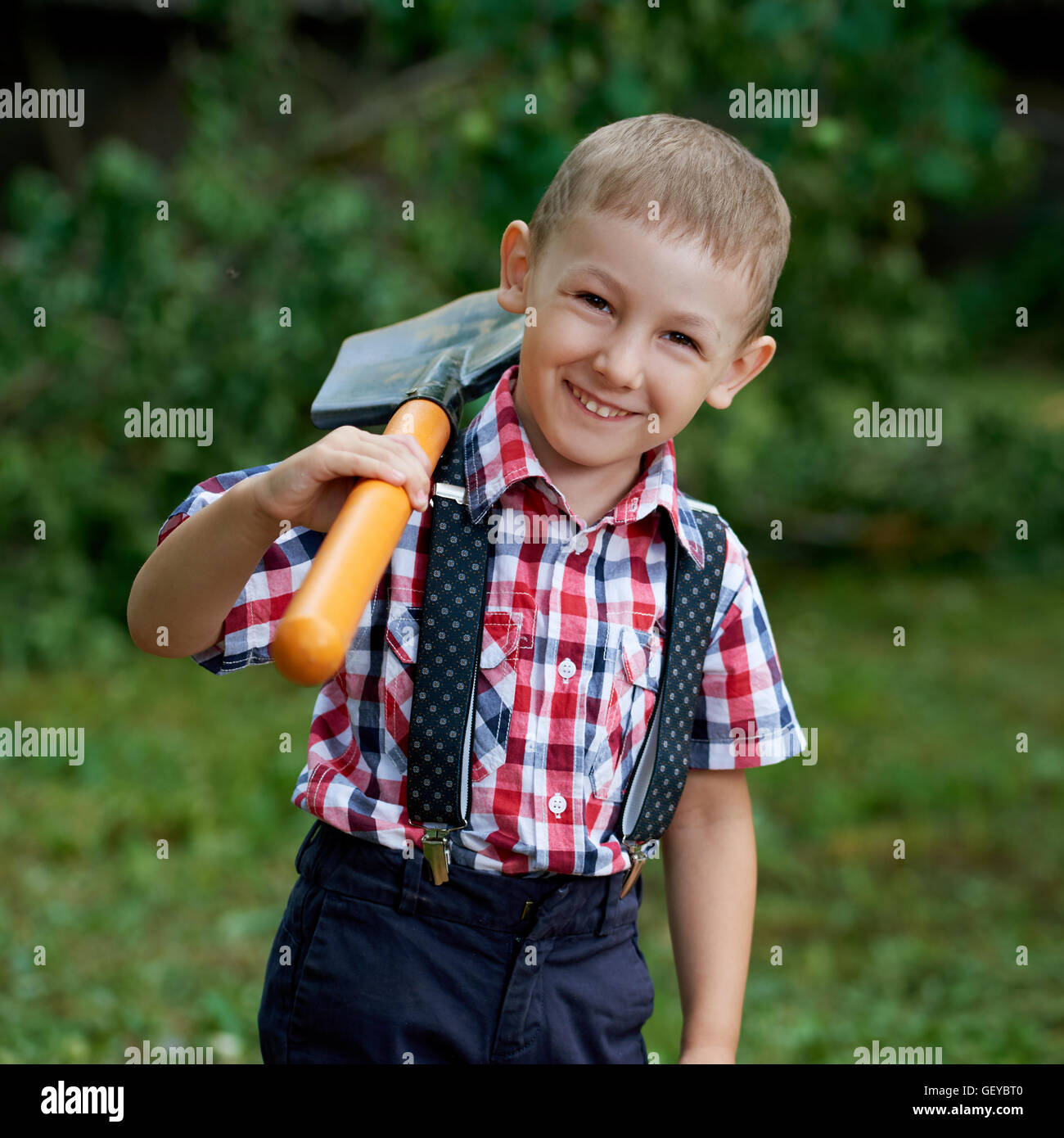 funny boy with shovel in garden Stock Photo - Alamy