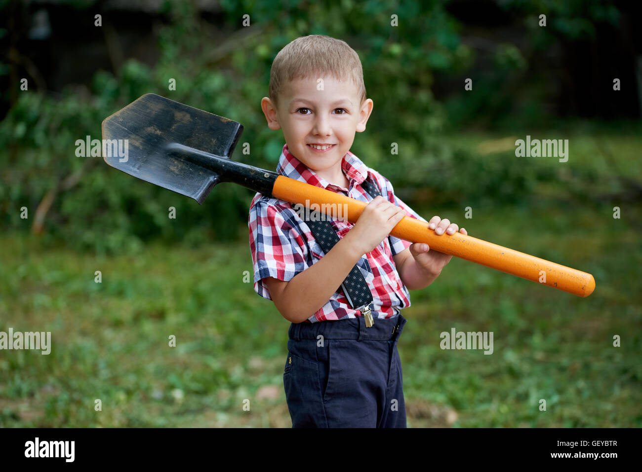 funny boy with shovel in garden Stock Photo - Alamy