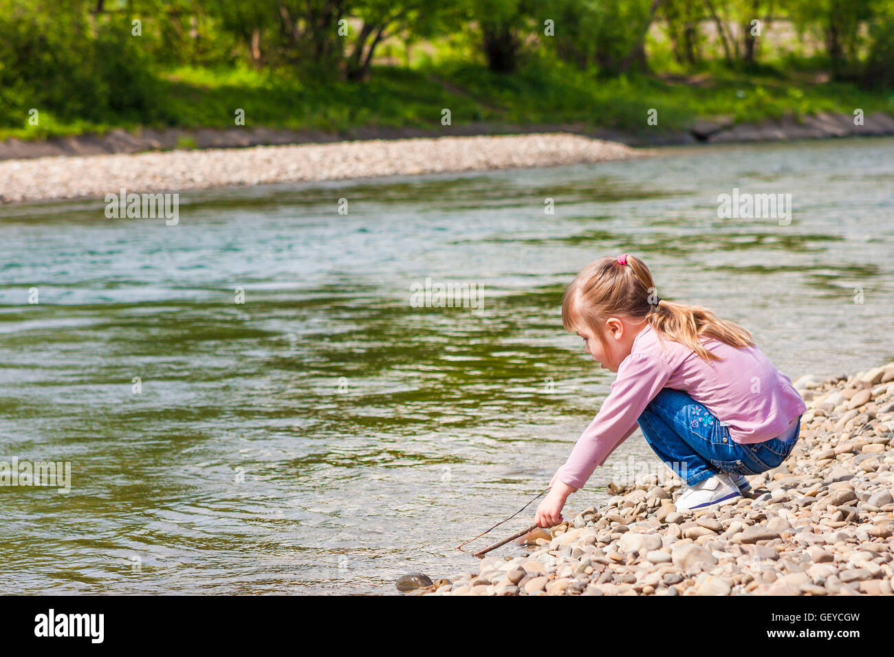 Little girl playing near the river Stock Photo - Alamy