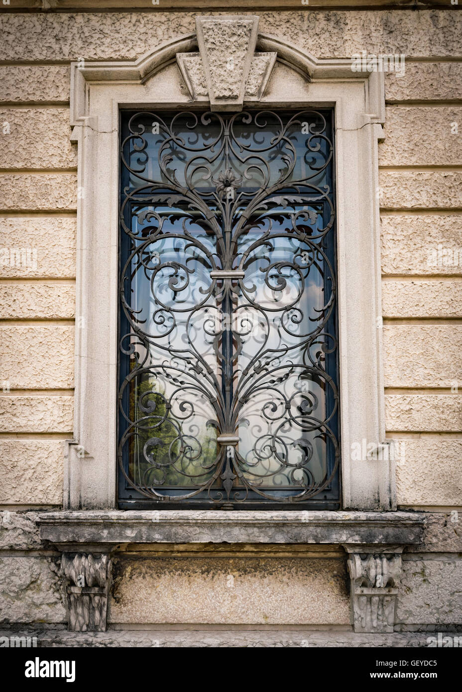Window of an ancient Italian villa with artistic iron grill handmade. Stock Photo