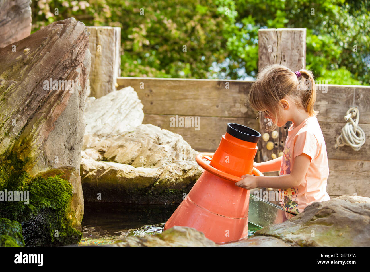 Little girl preschooler looking into water magnifying glass learning about marine life science education concept Stock Photo
