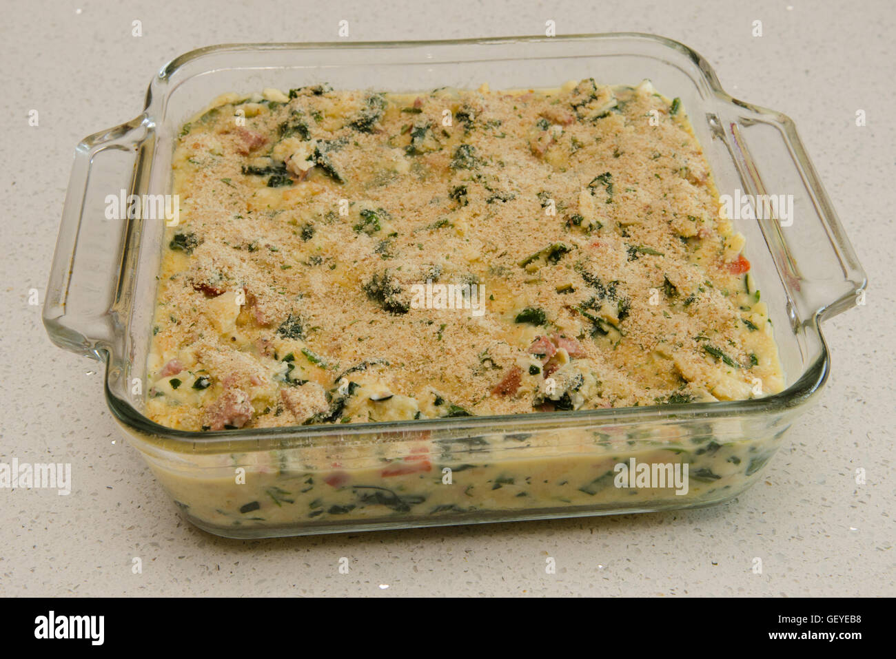 prepared casserole with bread crumbs in glass baking dish before baking Stock Photo