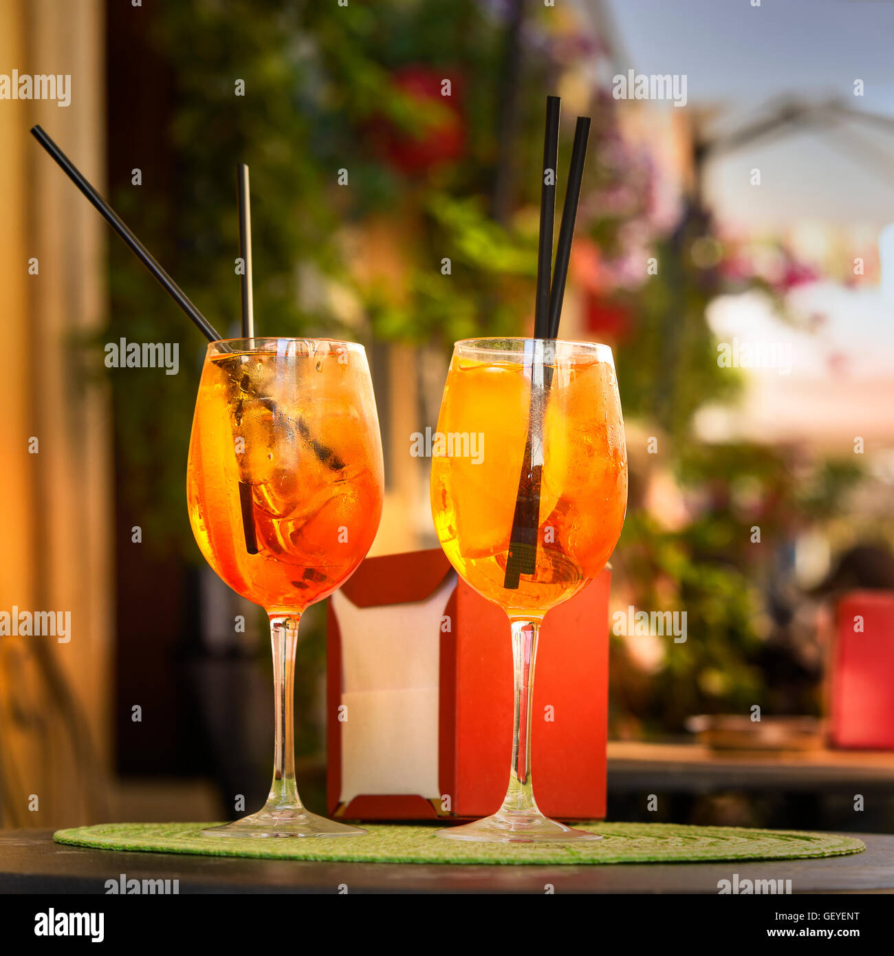 Aperol Spritz Cocktail. Alcoholic beverage based on table with ice cubes and oranges. Stock Photo