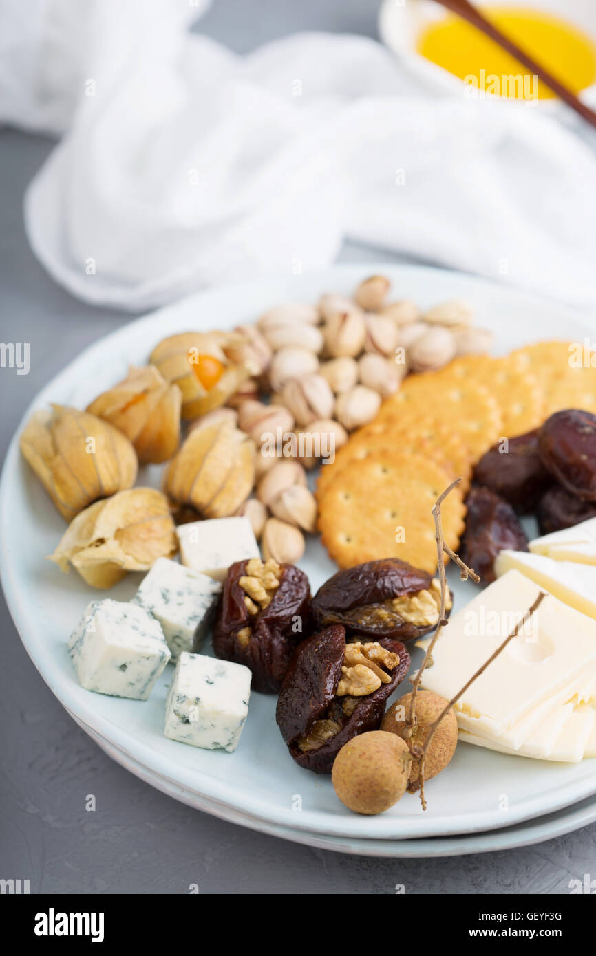 Cheese plate with crackers, dates and nuts Stock Photo Alamy
