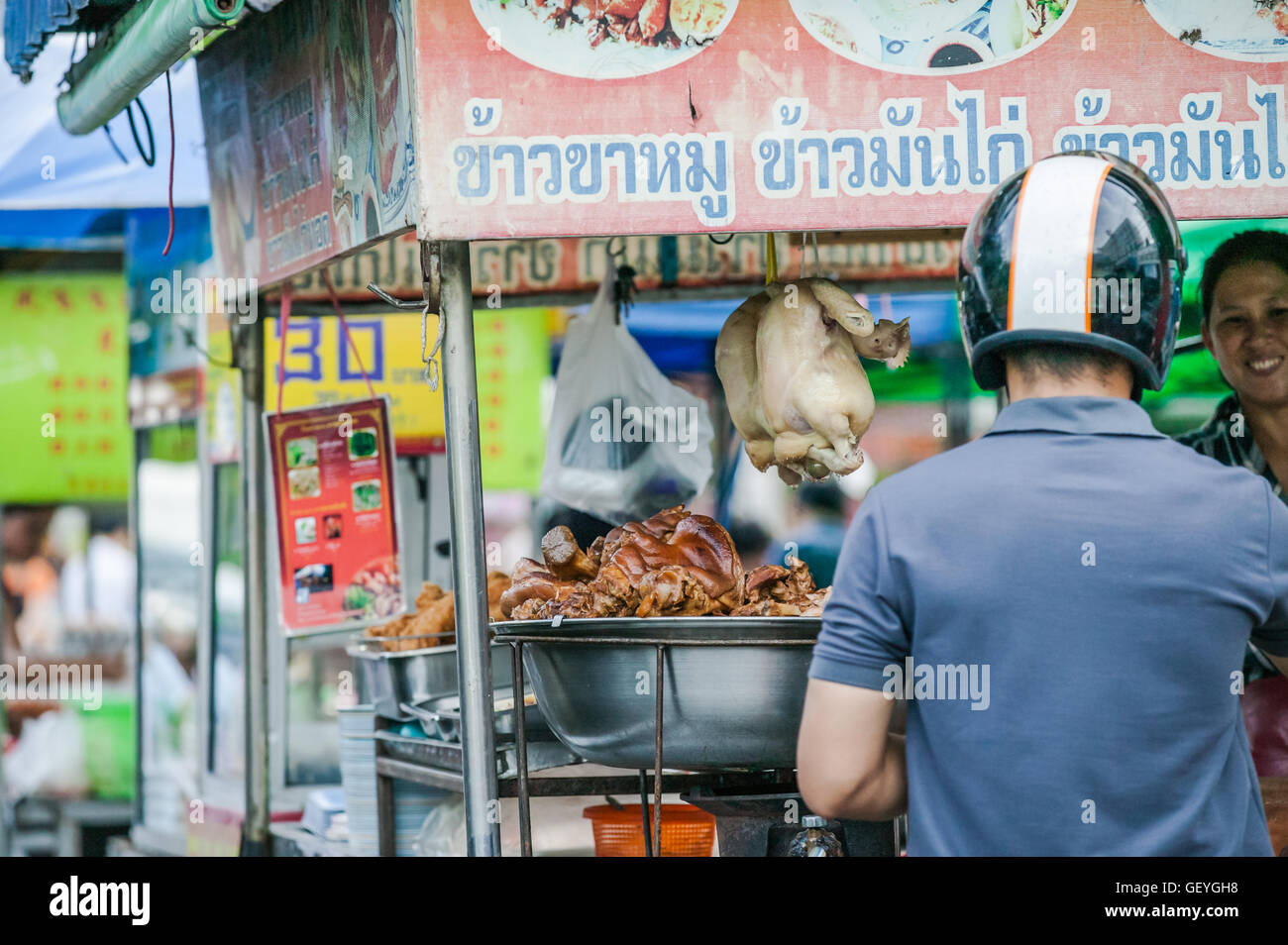 Man with helmet on,Food market by Chang Phuak Gate,north gate Chiang Mai Thailand Stock Photo