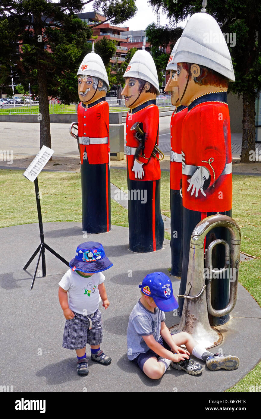 Military Brass Band bollards, by artist Jan Mitchell, with small boys playing on waterfront park in Geelong, Victoria, Australia Stock Photo