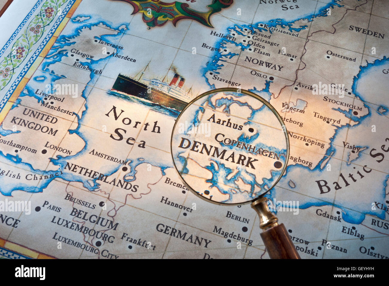 DENMARK COPENHAGEN AARHUS Old style map with magnifying glass over Denmark-Copenhagen-Aarhus. Cruise ship featured in North Sea with UK & Europe Stock Photo
