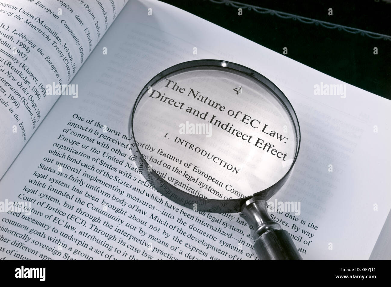 BREXIT Concept image of open EU reference Law book on desk with magnifying glass highlighting EC Law effects Stock Photo