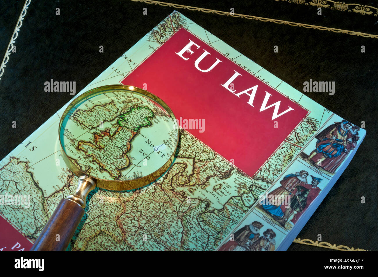EU Law book on desk with magnifying glass highlighting UK within map of Europe Stock Photo