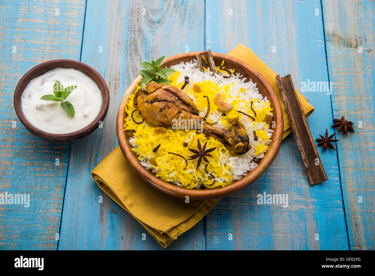 Chicken Biryani with yogurt dip on beautiful moody background