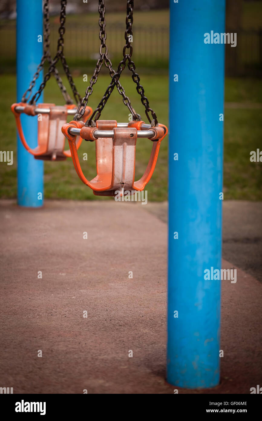 Two empty swings in an outdoor playground Stock Photo