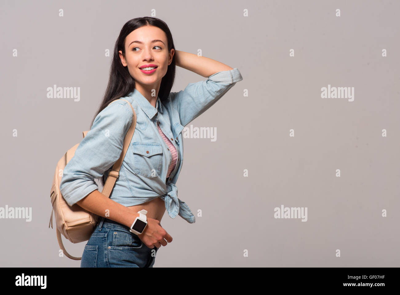 Positive woman standing isolated on grey background Stock Photo - Alamy