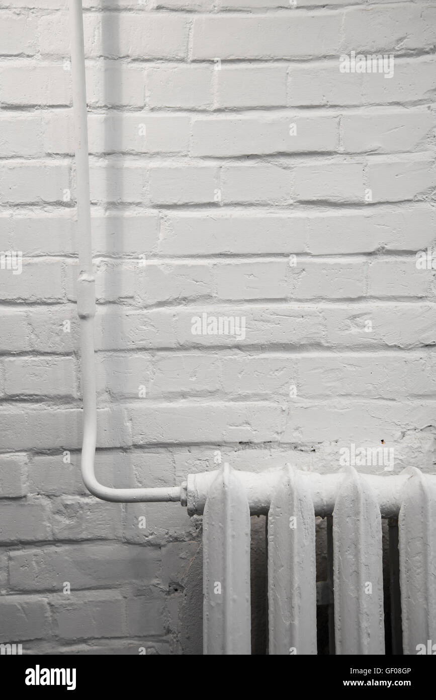 radiator against a white brick wall Stock Photo - Alamy