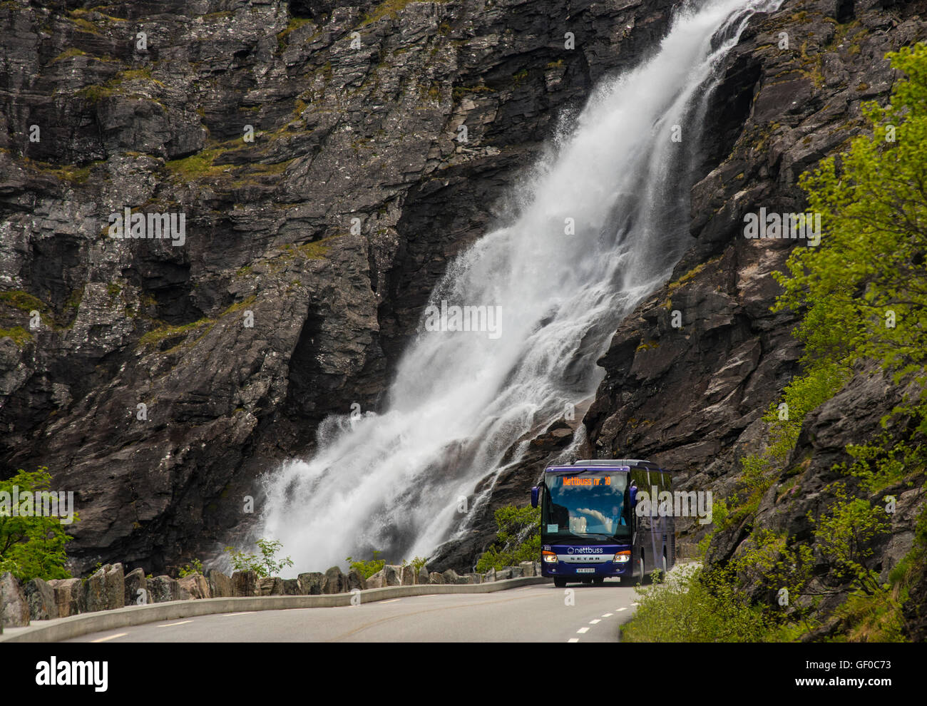 Motorcoach driving Trollistigen Mountain Road, StigFossen Waterfalls in background, Rienheimen Nat. Park, Norway Stock Photo