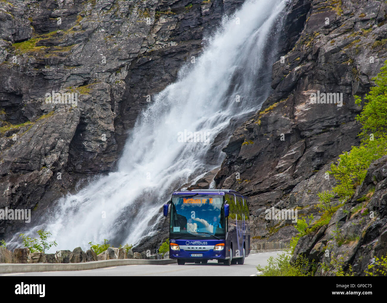 Motorcoach driving Trollistigen Mountain Road, StigFossen Waterfalls in background. Rienheimen Nat. Park, Norway, Scandinavia Stock Photo