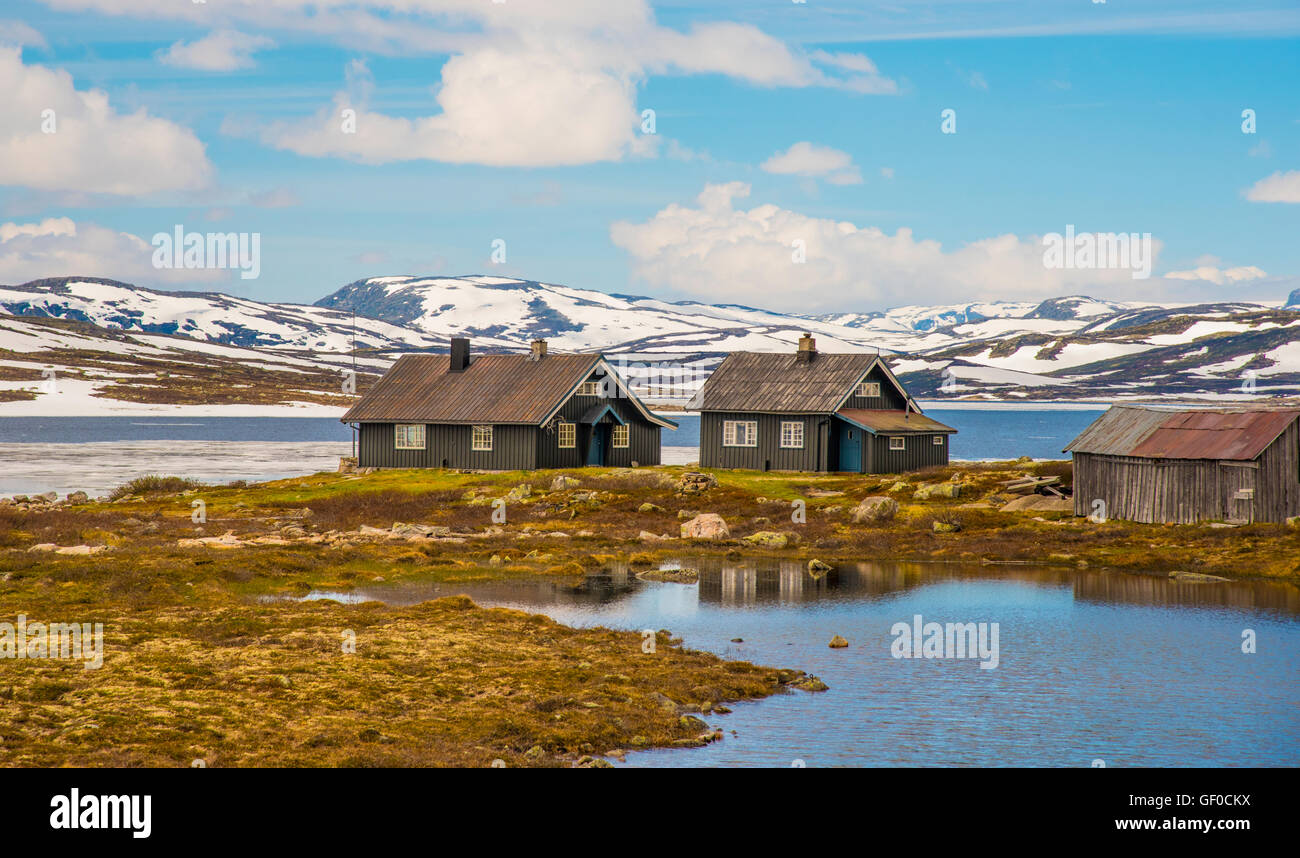 Lake Orteren in springtime rental cabins reflections. Hardangervidda National Park, Norway, Hordaland, Scandinavia, European Stock Photo