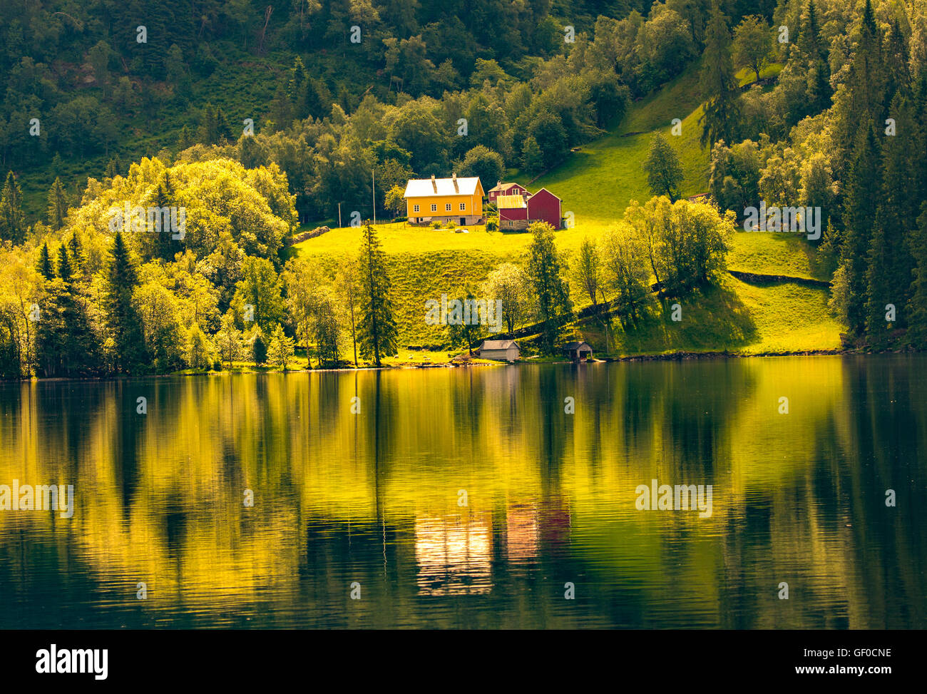Colorful Farm reflecting in Mountain Lake between Bergen and Alesund, Norway, Scandanavia, European Stock Photo
