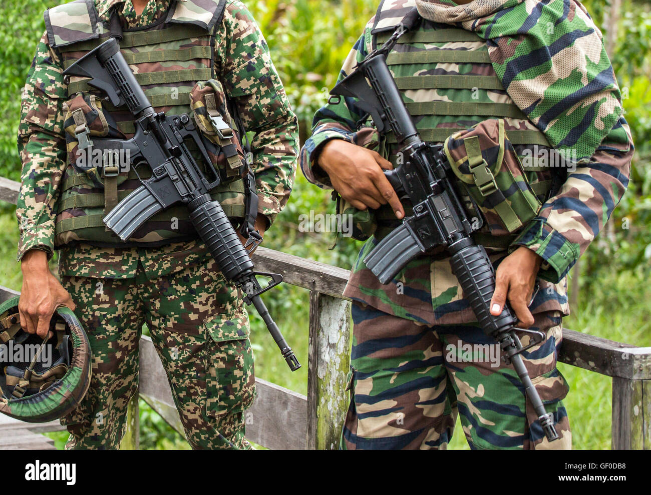 Two unrecognised malaysian soldiers holding their assault rifles Stock Photo