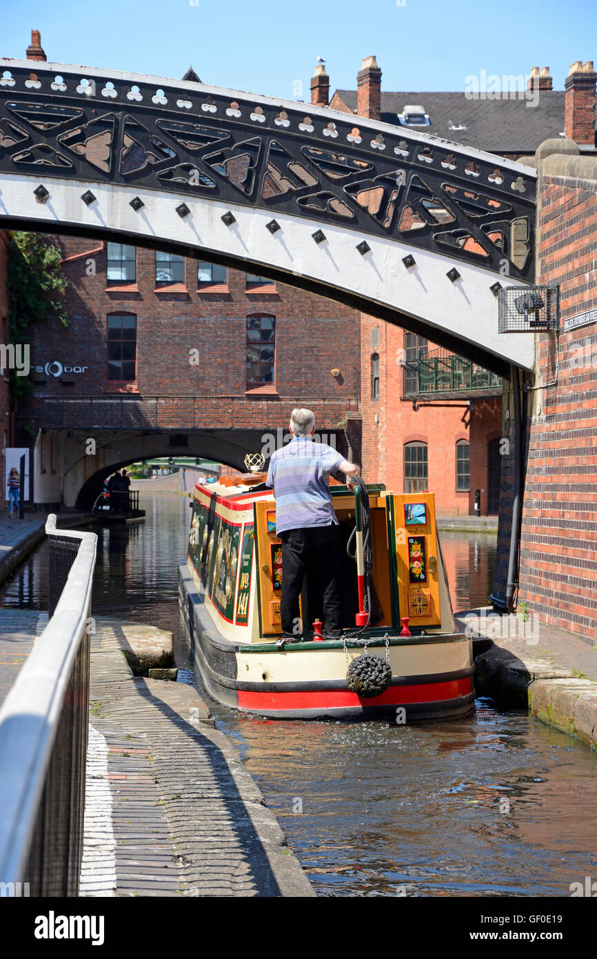 Man steering a narrowboat under a bridge hi-res stock photography and ...