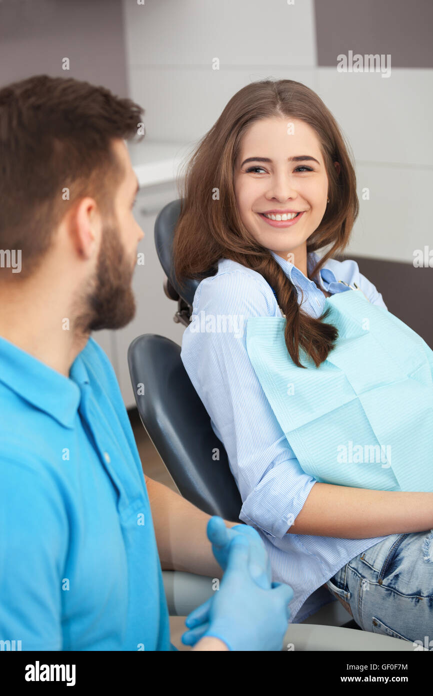 Portrait of a male dentist and young happy female patient in a dentist