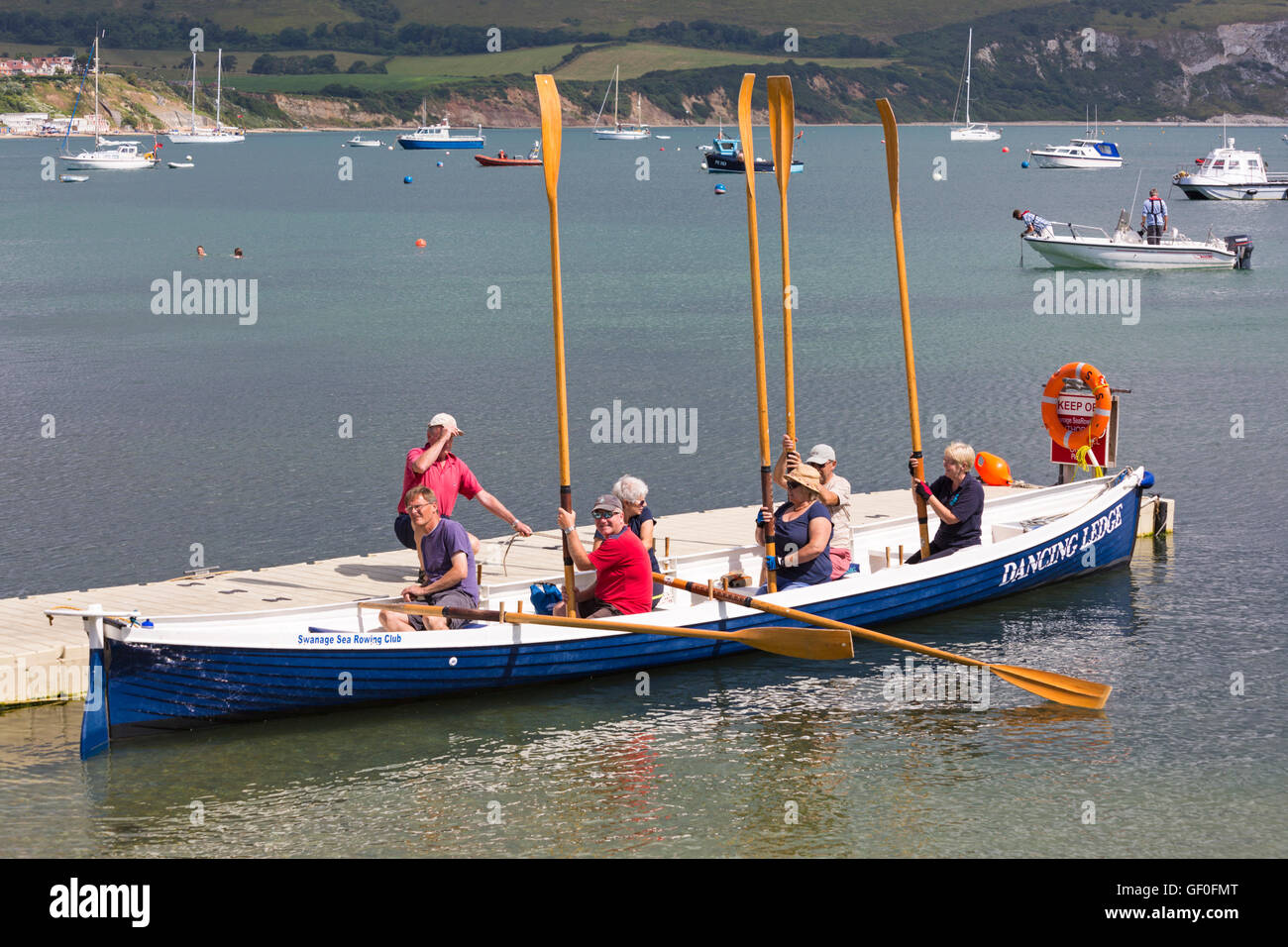 Swanage Sea Rowing Club in Dancing Ledge gig holding oars up at Swanage