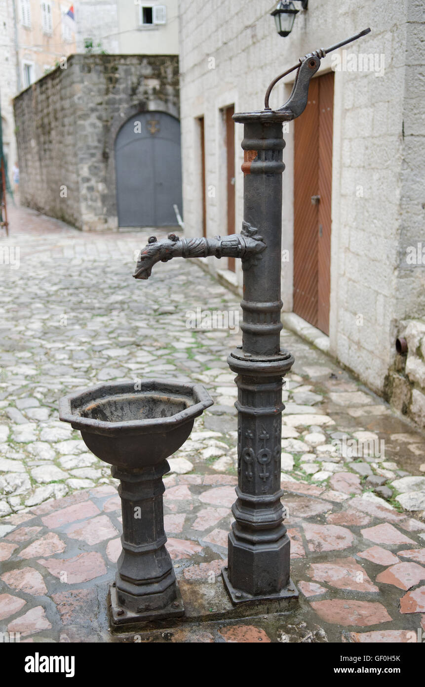 Medieval hand pump for water in cobbled stone square of old town Montenegro Stock Photo