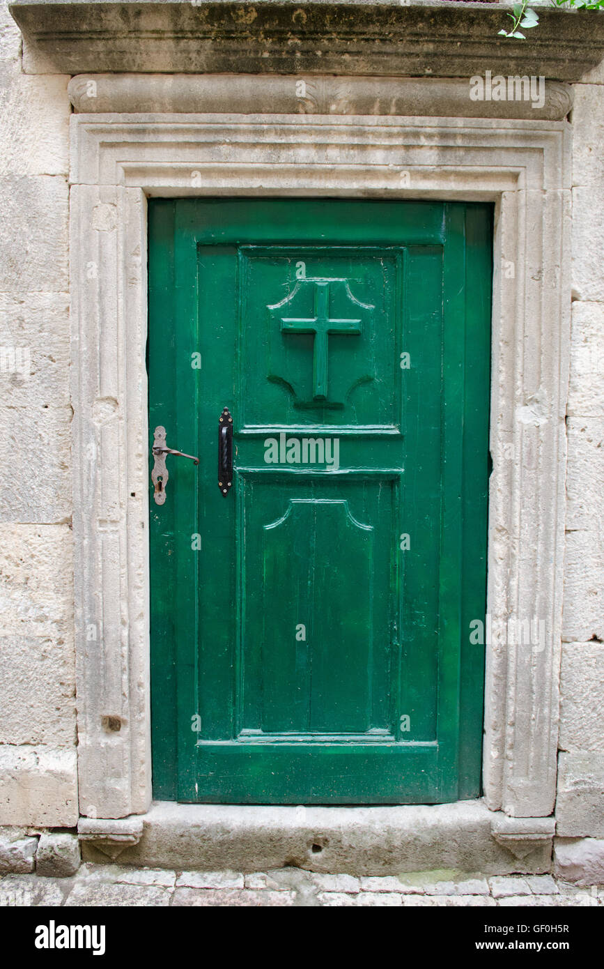 Green doorway in old town with Christian cross Stock Photo