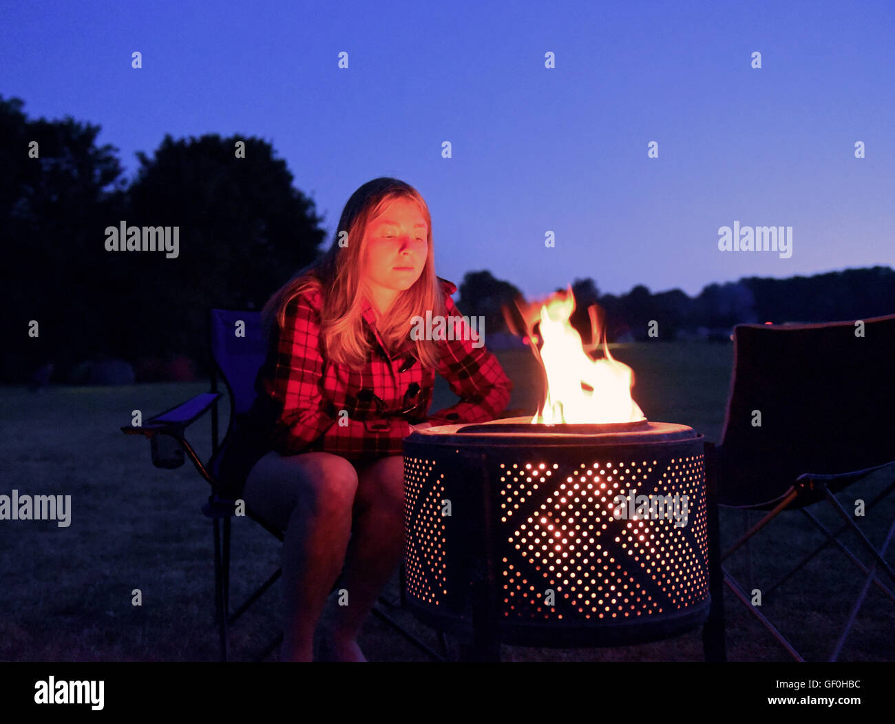 Girl Sits Staring At The Flames Of Her Camp Fire At Kingsdown Campsite Near Deal Kent Stock 7670