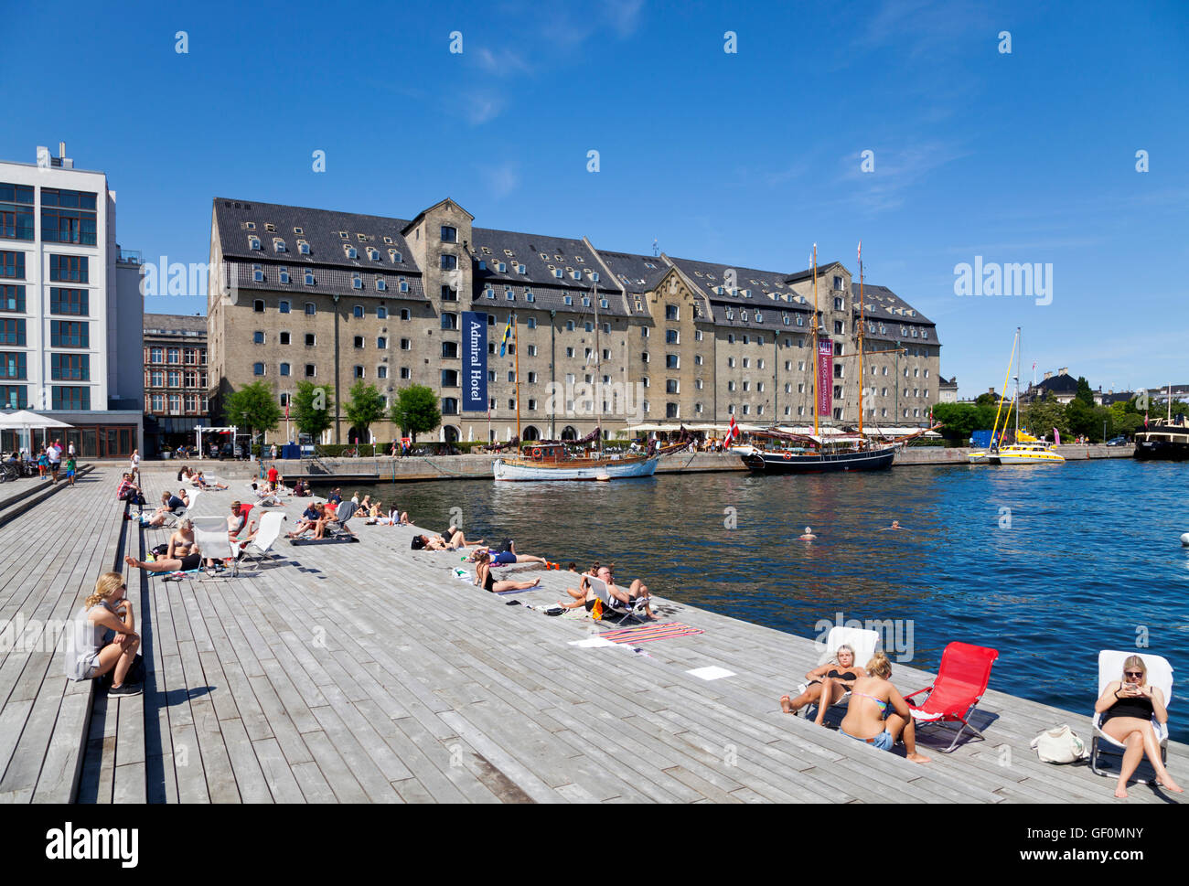 The sun deck at the new Kvæsthus Pier Urban Space and the Admiral Hotel, Copenhagen, Denmark. People swimming and sunbathing. Urban beach. Kvaesthus. Stock Photo