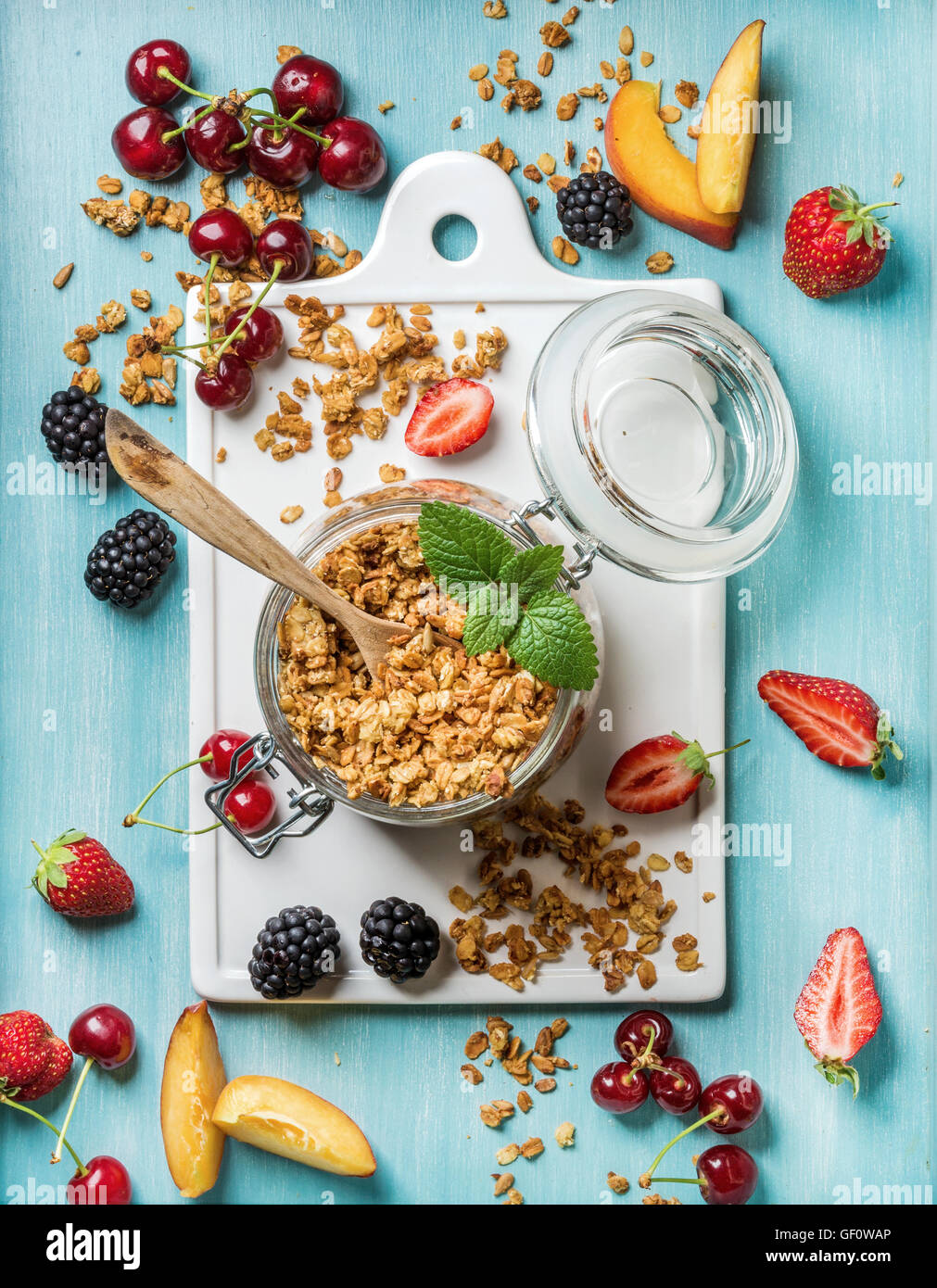 Healthy breakfast ingredients. Oat granola in open glass jar, fruit