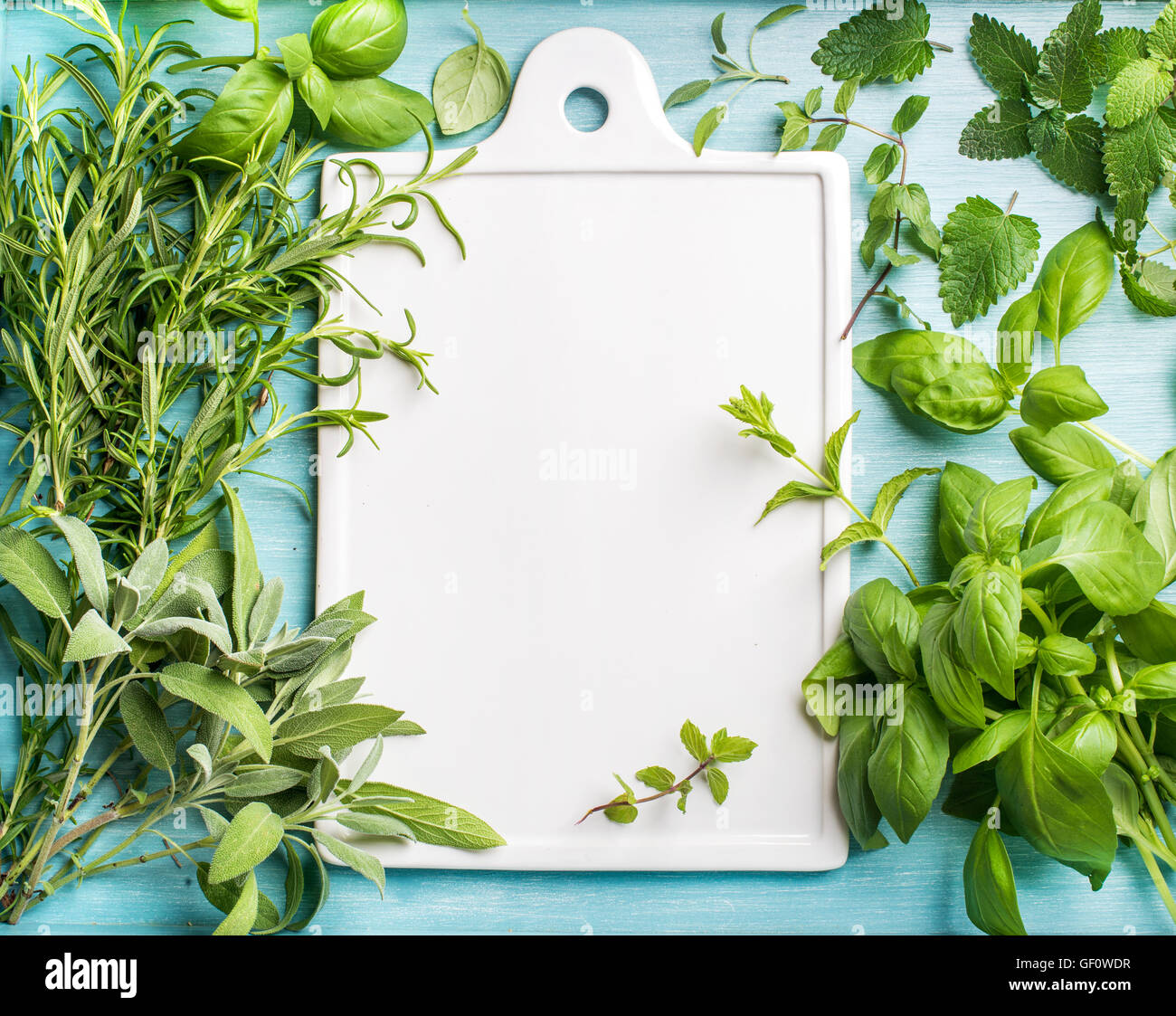 Fresh green cooking herbal assortment. Sage, basil, rosemary, melissa and mint on blue background with copy space Stock Photo