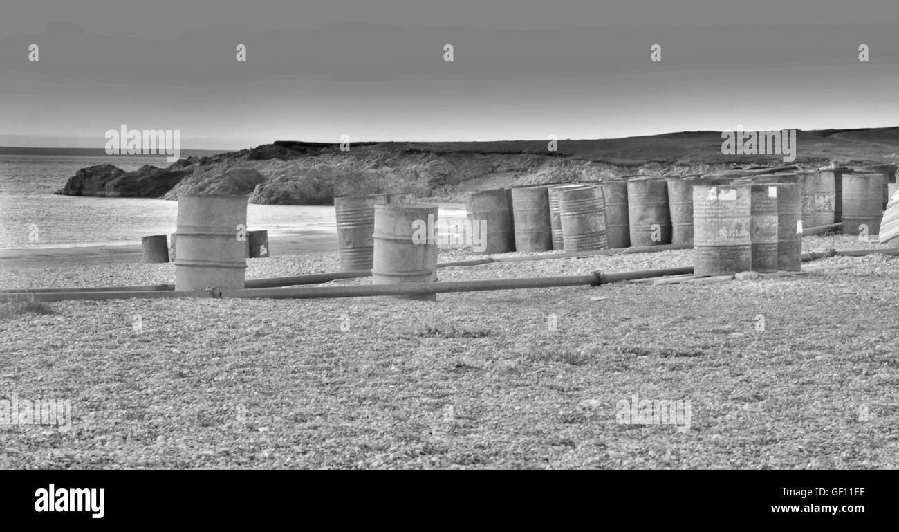 Old casks with fuel tubing laid on beach for Barents sea. Pollution Of Arctic Stock Photo