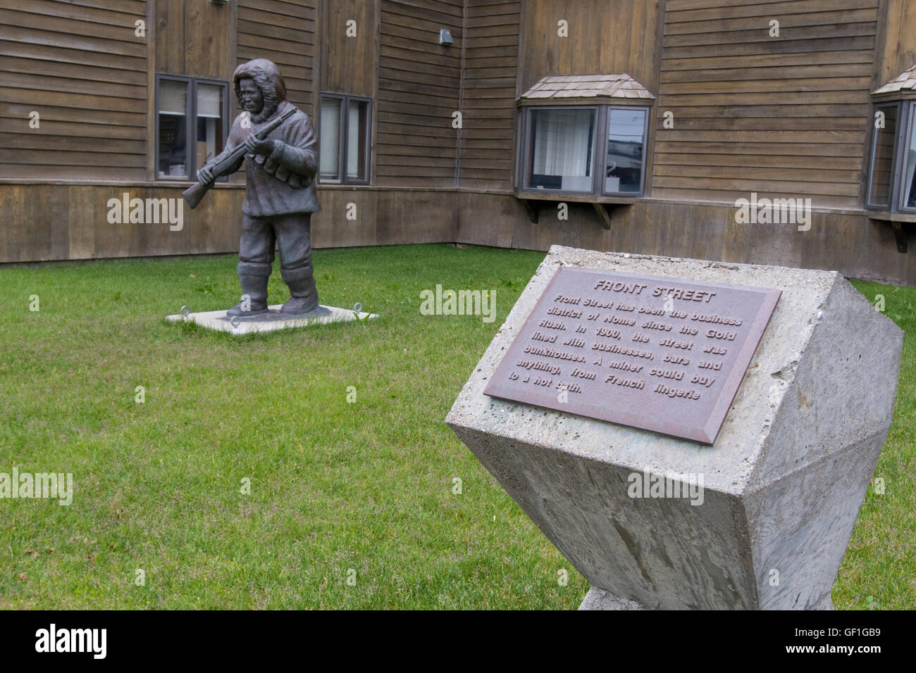 Alaska, Nome. The Old Federal Building, home to the Bering Strait Native Corp. Bronze statue. Stock Photo