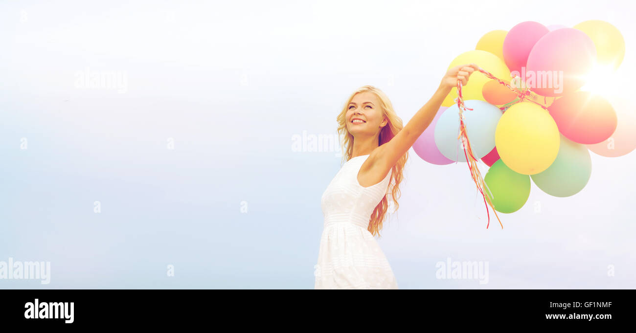 smiling woman with colorful balloons outside Stock Photo