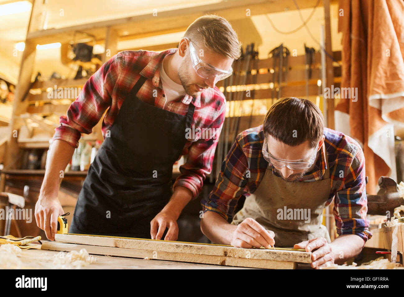carpenters with ruler and wood plank at workshop Stock Photo - Alamy