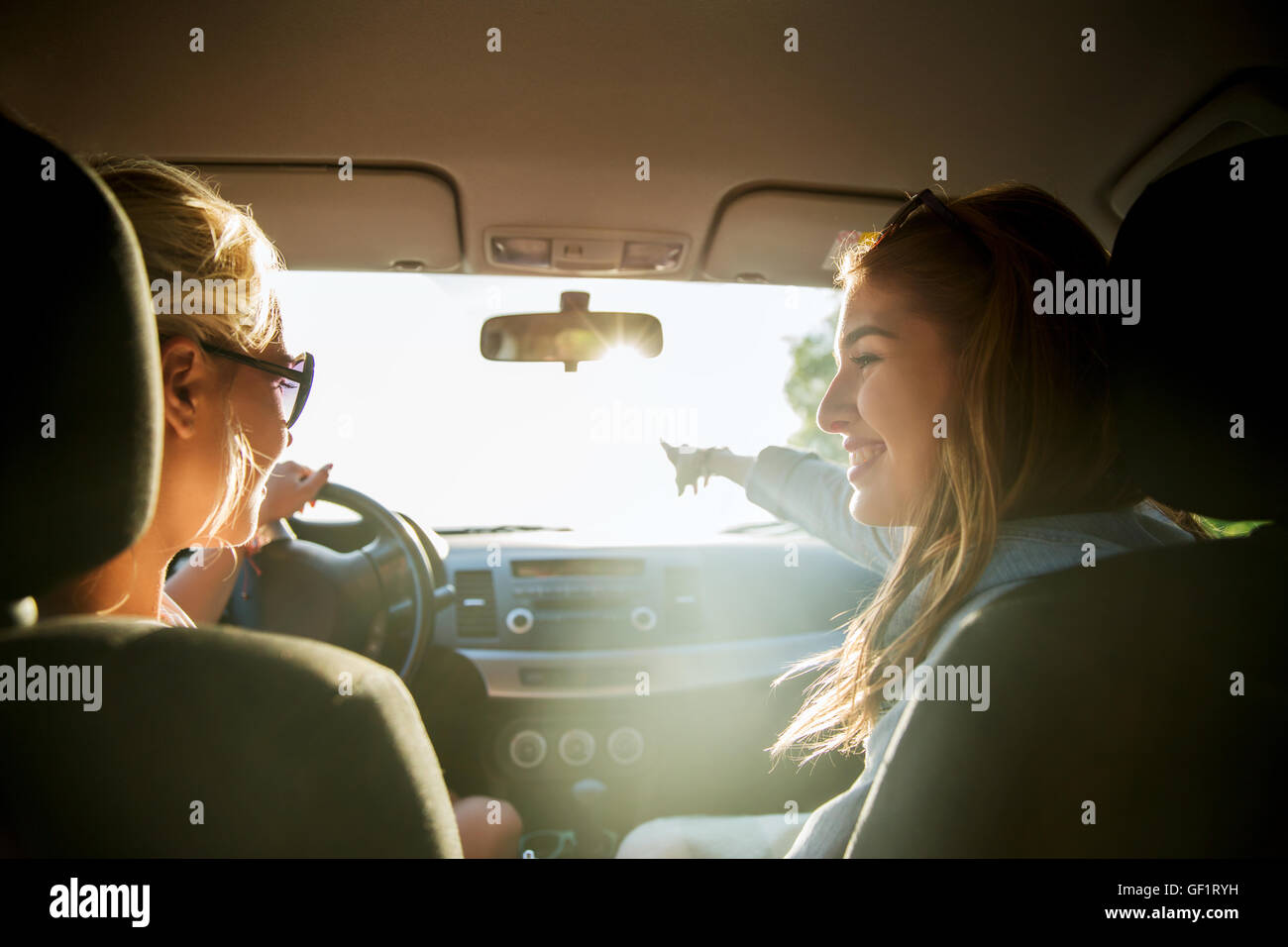 happy teenage girls or women in car at seaside Stock Photo - Alamy
