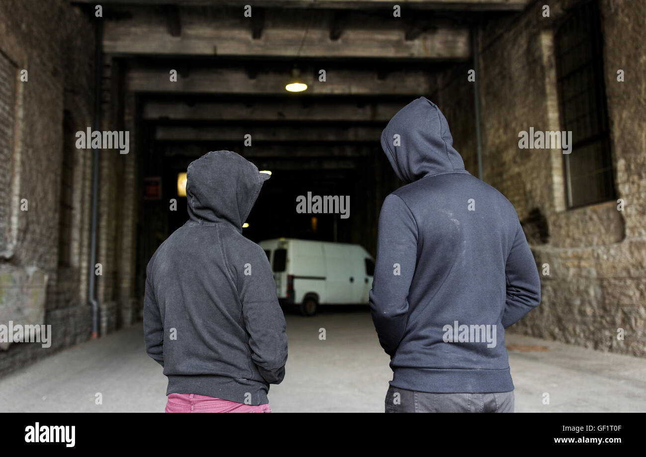 addict men or criminals in hoodies on street Stock Photo