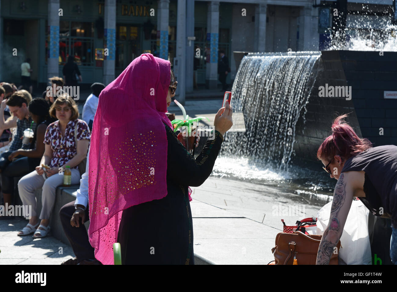 Muslim woman in Pink hijab, taking photograph on mobile phone. Stock Photo