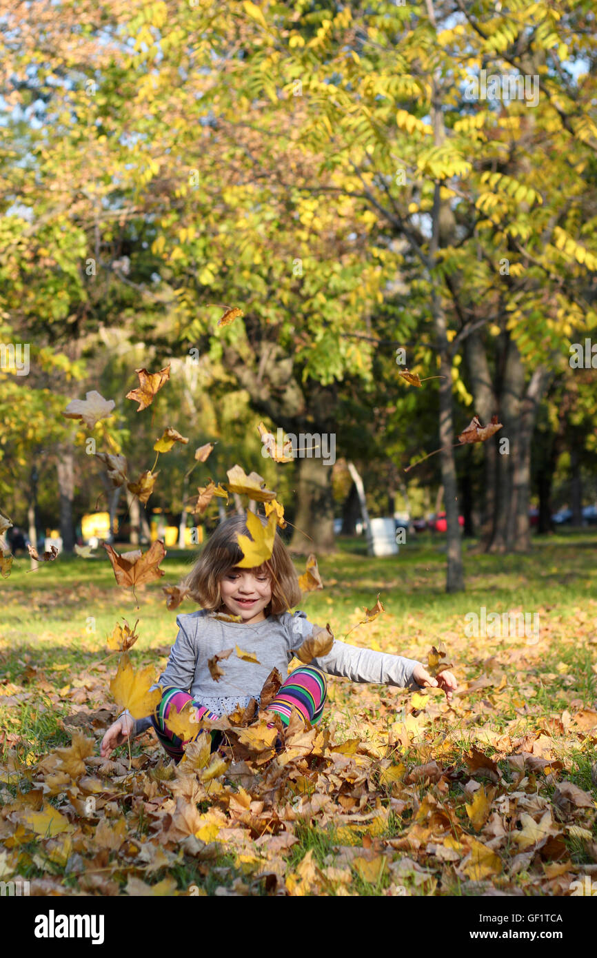 little girl play with autumn leaves Stock Photo - Alamy