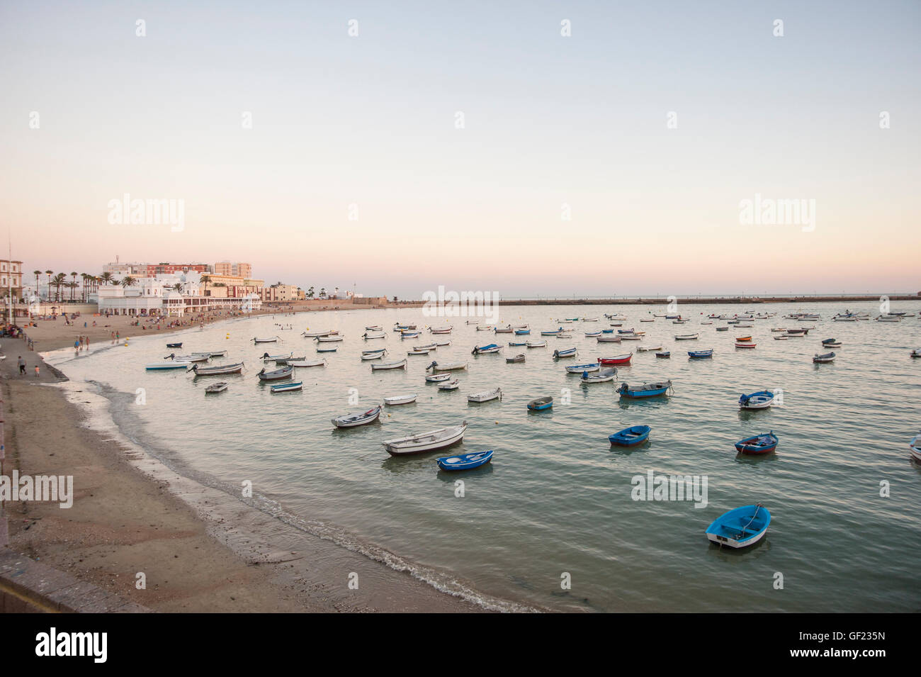 View of La Caleta beach, at sunset.    La Caleta is a small beach located at the tip of the historic quarter of Cádiz. Stock Photo