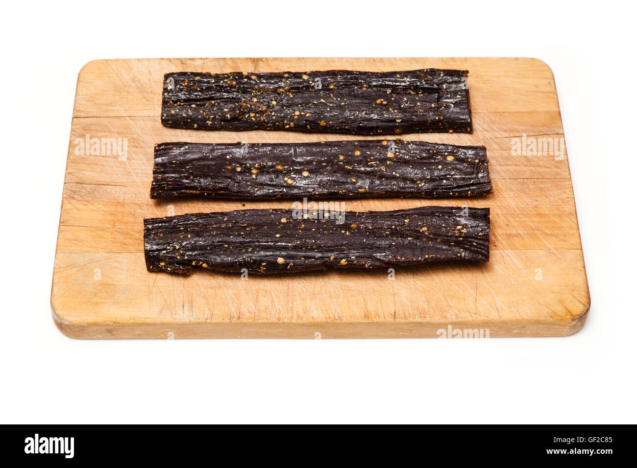 Beef Biltong , South African beef jerky on a wooden chopping board. Stock Photo