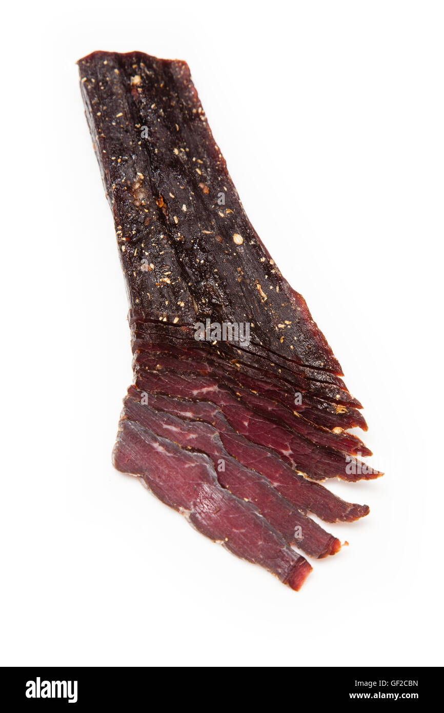 South African beef biltong or jerky whole and sliced isolated on a white studio background. Stock Photo