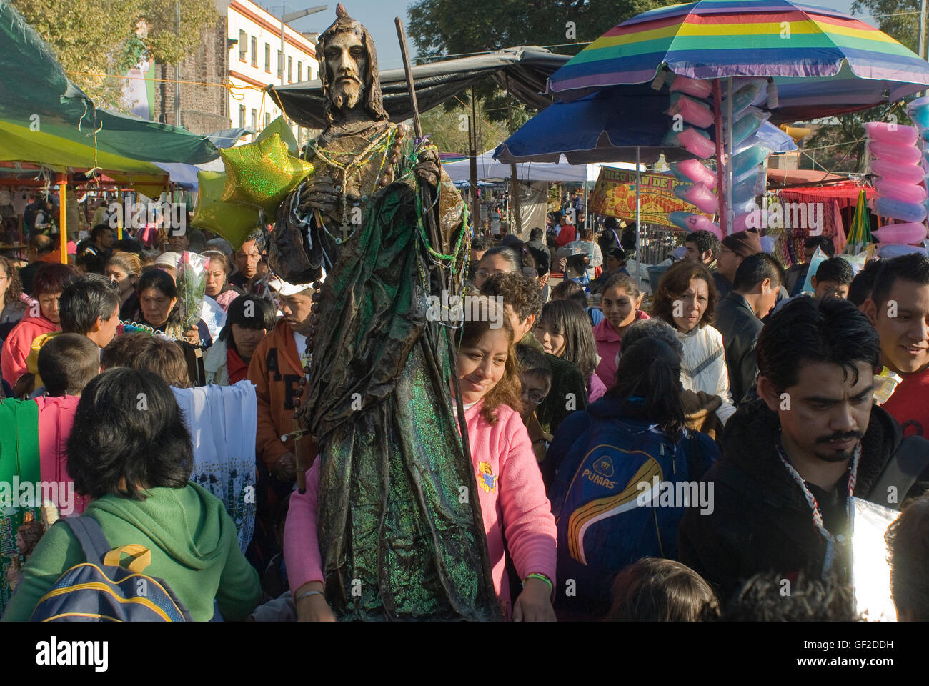 A woman carrying a large statue of Saint Jude Thaddeus, the patron of lost causes, walks in the crowd on the saint's feast day. Stock Photo