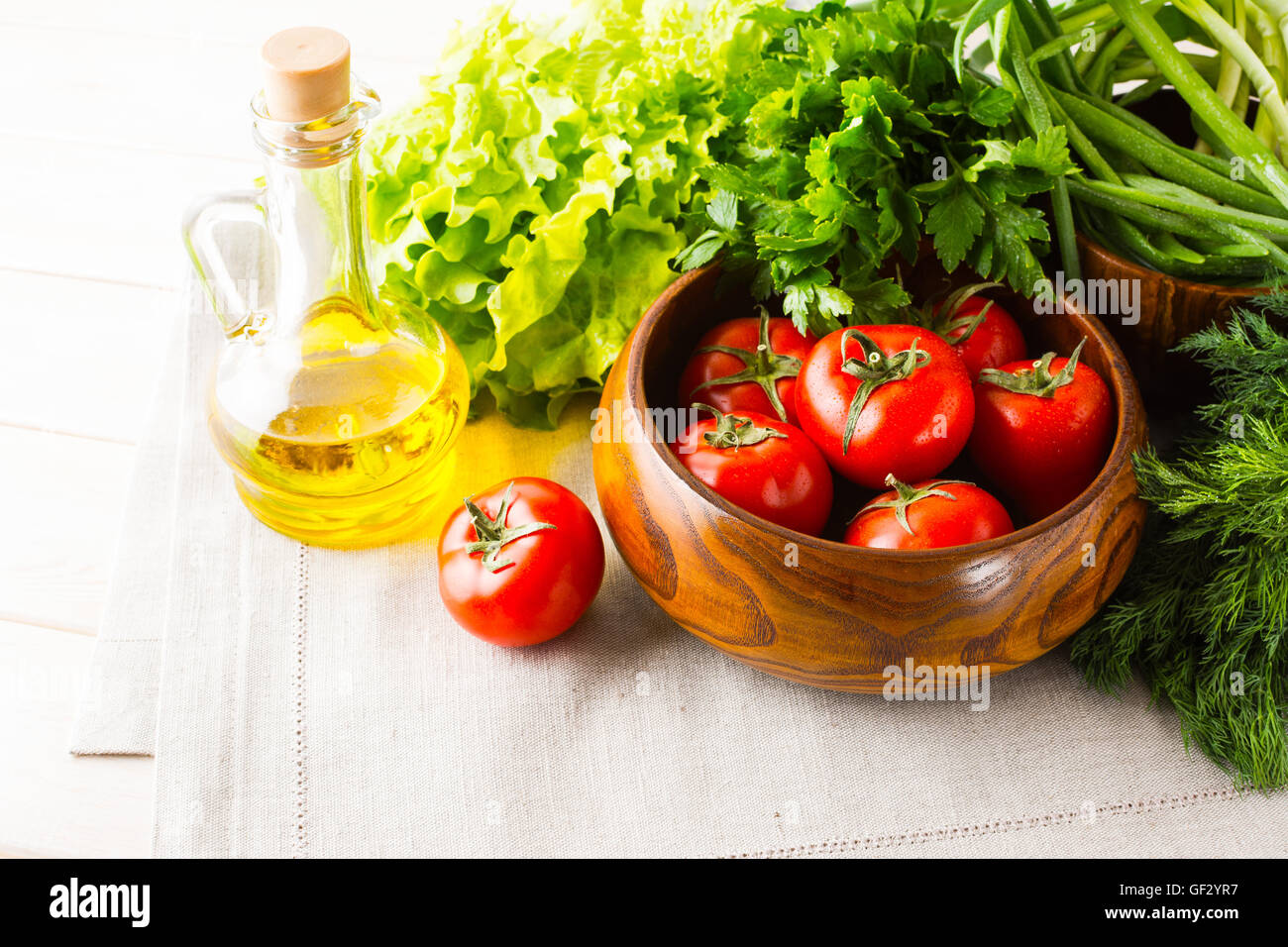 Vegetables and olive oil on the white wooden background. Healthy eating background. Detox or vegetarian food concept with fresh Stock Photo