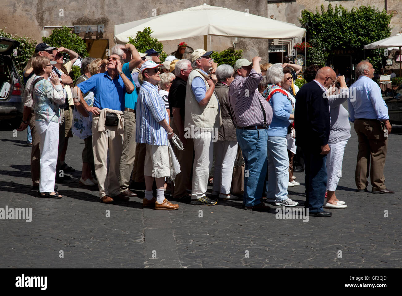 German tourists look at the Duomo on a tour in Orvieto, Italy while one man  looks at something else Stock Photo - Alamy