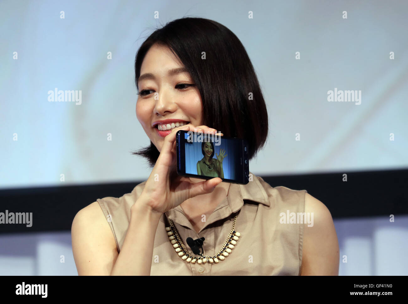 Tokyo, Japan. 28th July, 2016. Japanese actress Kaori Manabe (R) displays a picture of a smart phone for senior people "Basio2", taken by actor Ryotaro Sugi in Tokyo on Thursday, July 28, 2016. The 71-year-old veteran drama actor used the smart phone for the first time. © Yoshio Tsunoda/AFLO/Alamy Live News Stock Photo