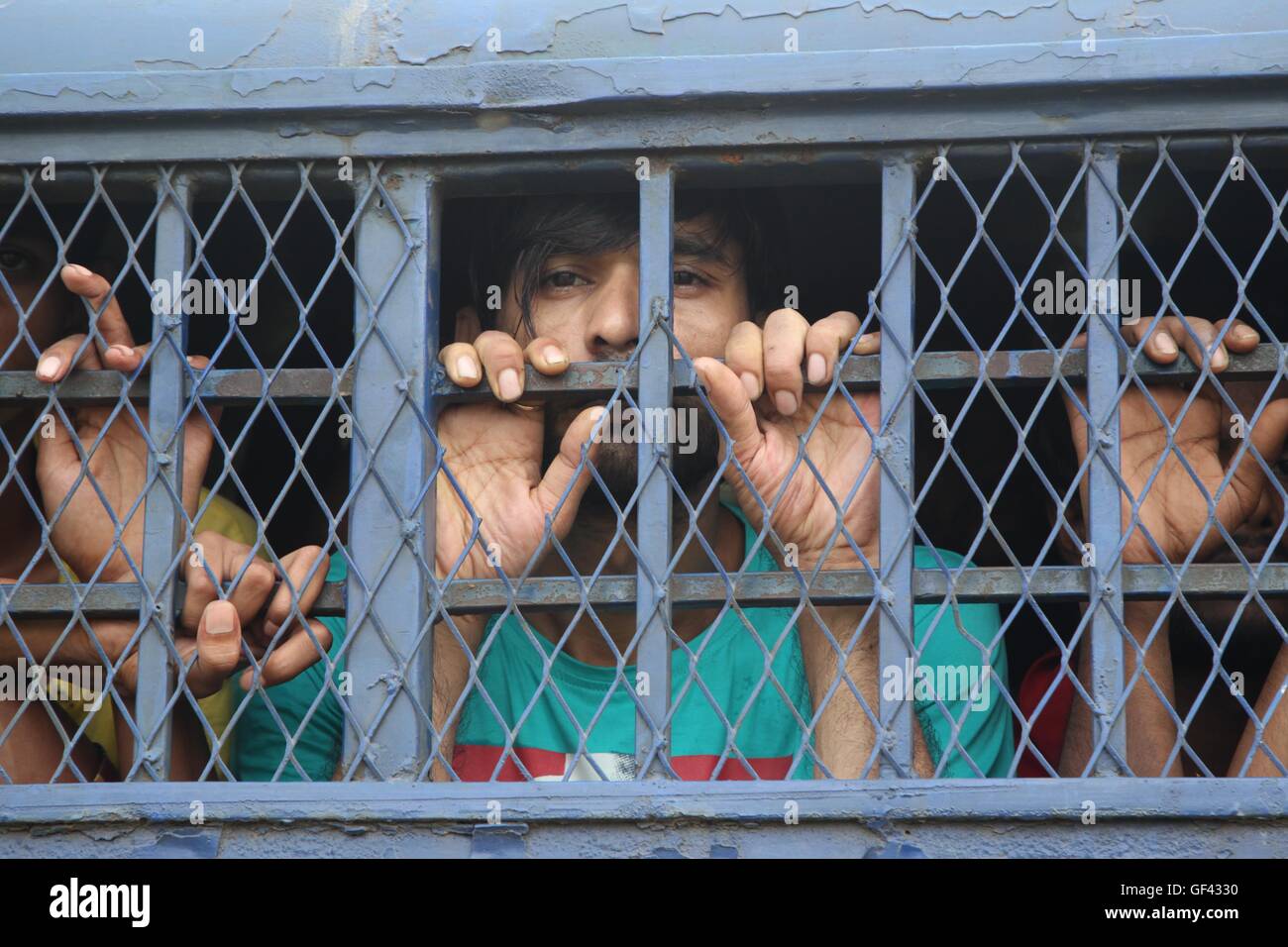 Dhaka, Keranigonj, California, Bangladesh. 29th July, 2016. A prisoners look through from the prison van as the shifting of prisoners from the 200-year-old Dhaka Central Jail to the newly built prison at Rajendrapur, in Keraniganj, has started on 29 July, 2016, Dhaka, Bangladesh. The new prison at Rajendrapur is located 12 kilometres away from the old one built in 1788 on Nazim Uddin Road. According to the local media report Prison authorities say the Dhaka Central Jail housed nearly 8,000 prisoners, 6,300 of them male, and the rest female inmates. The women prisoners were earlier shifted to Stock Photo