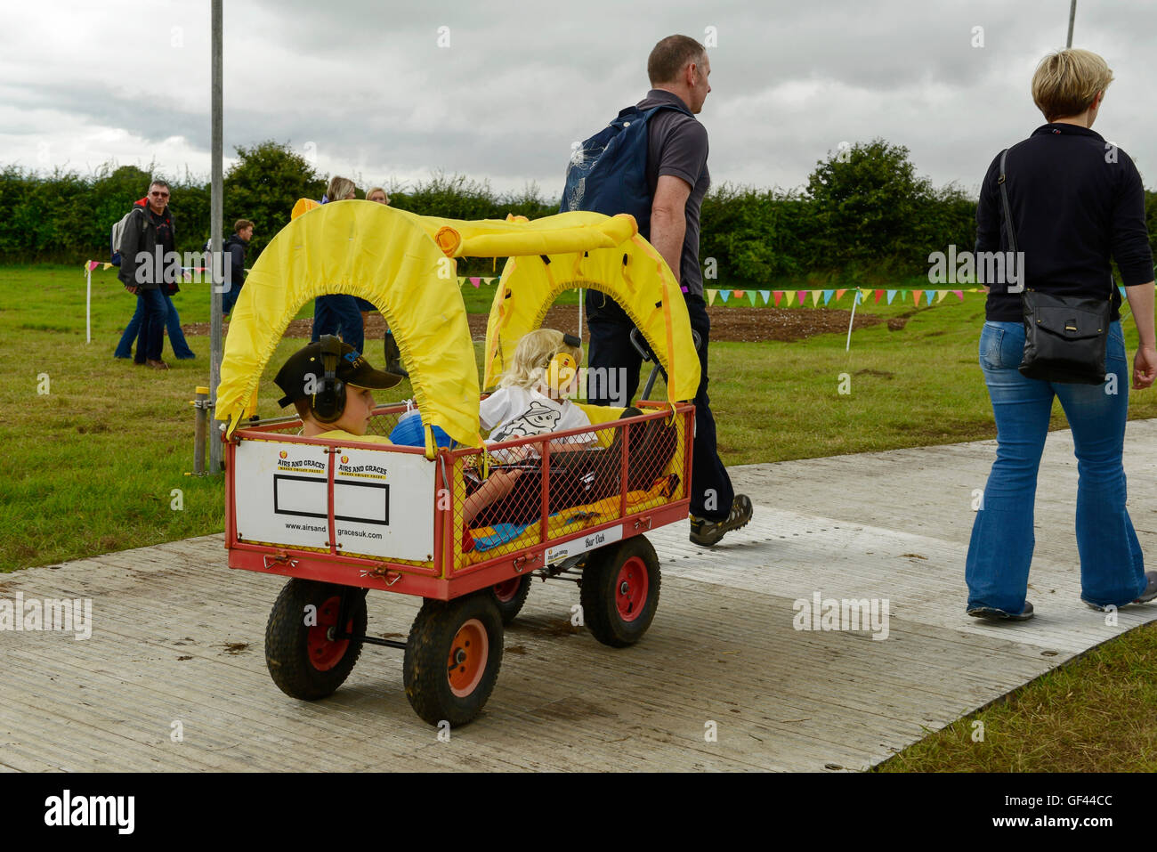 Carfest North, Bolesworth, Cheshire, UK. 29th July, 2016. Two children are transported around the site in the back of a trolley. The event is the brainchild of Chris Evans and features 3 days of cars, music and entertainment with profits being donated to the charity Children in Need. Credit:  Andrew Paterson/Alamy Live News Stock Photo