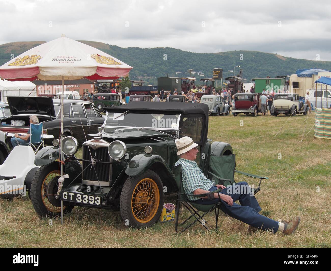 near Malvern, UK. 29th July, 2016. A vintage car enthusiast taking a bit of a rest by his Riley